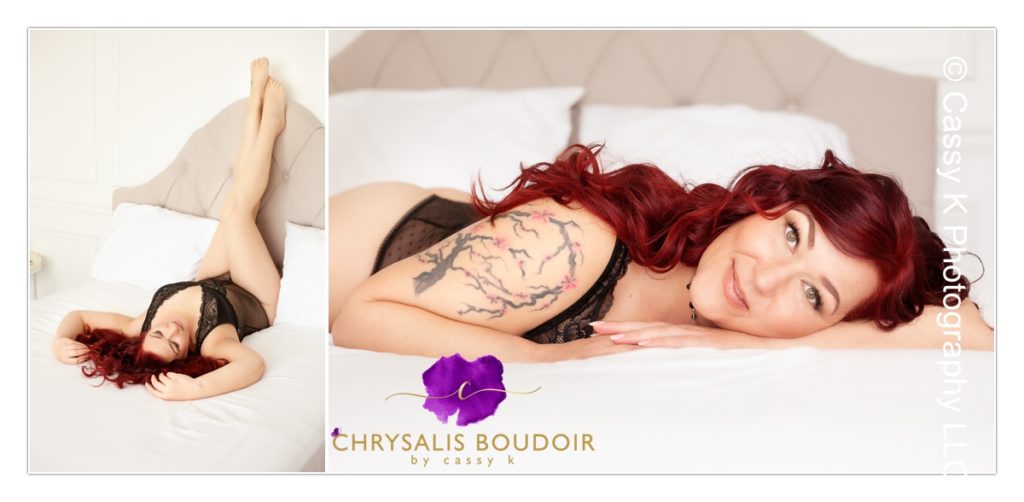 Curly Red Head single mom building confidence wearing black body suit laying on stomach on a white sheet for Boudoir Photoshoot