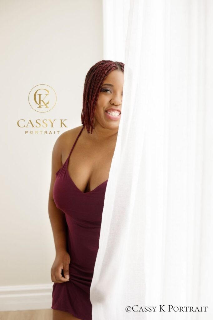 Black woman faces boudoir shoot fears smiling wearing burgundy mini dress