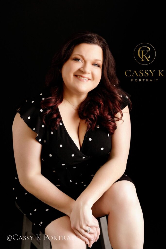 Black haired Blue eyed woman wearing black and white dress has renewed confidence after Boudoir headshot Photoshoot