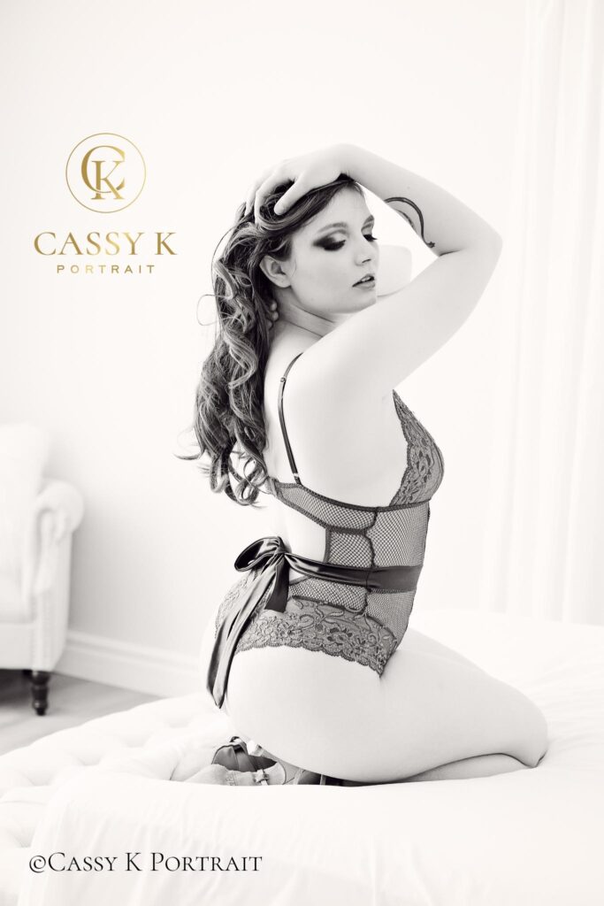 Red haired hazel eyed woman wearing green lace lingerie on bed does boudoir photo shoot for self-love
