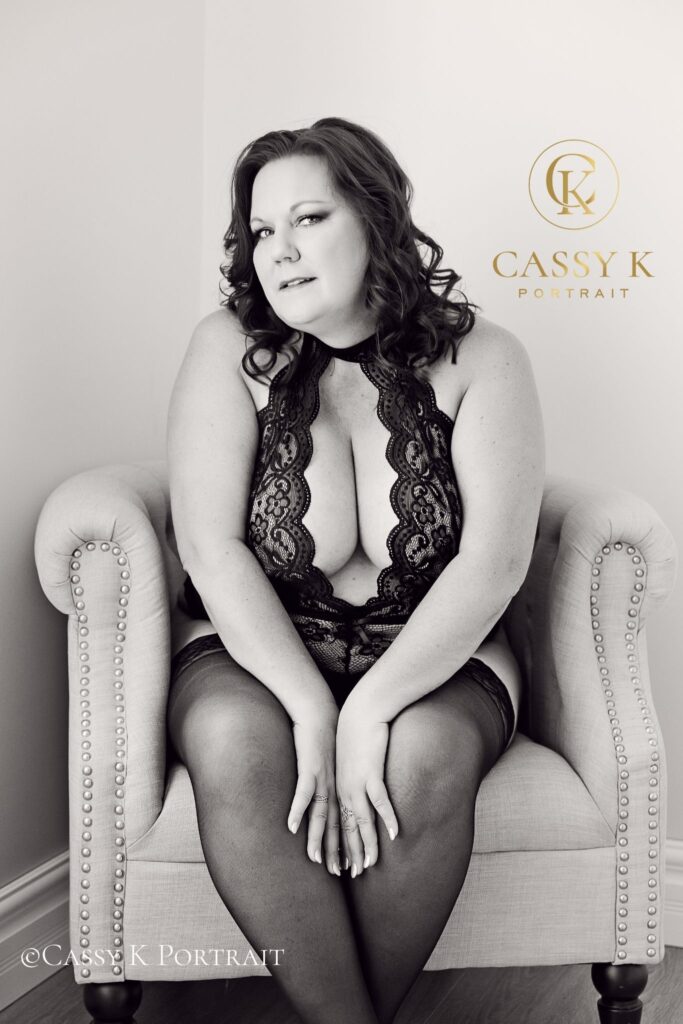 Plus size Red head with hazel eyes touching legs wearing black lingerie boudoir confidence