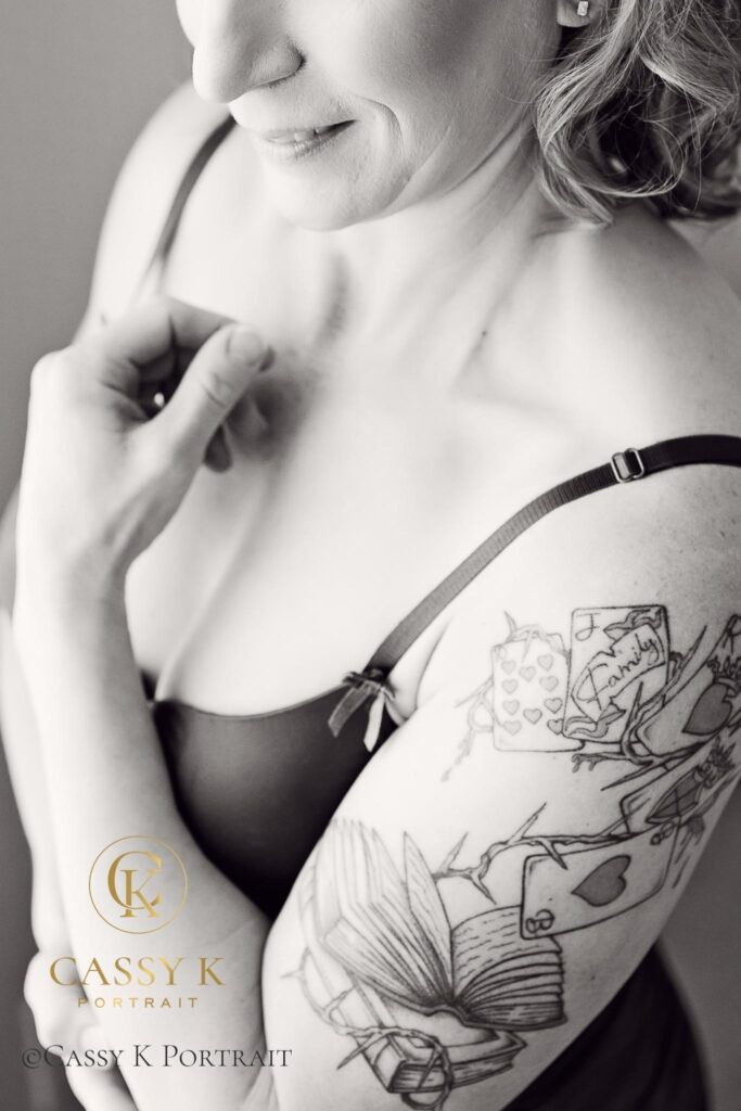 Blond haired blue eyed woman wearing pink slip does Black and white boudoir photo shoot for 50th birthday and anniversary