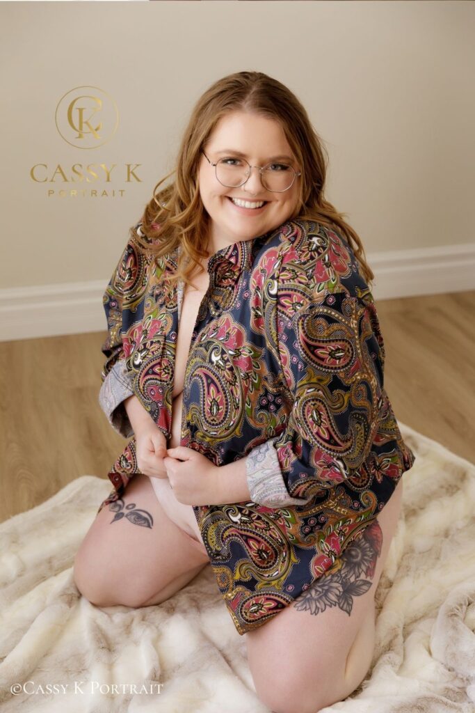 bride to be celebrates an Authentic Boudoir Experience smiling while wearing fiance's paisley shirt