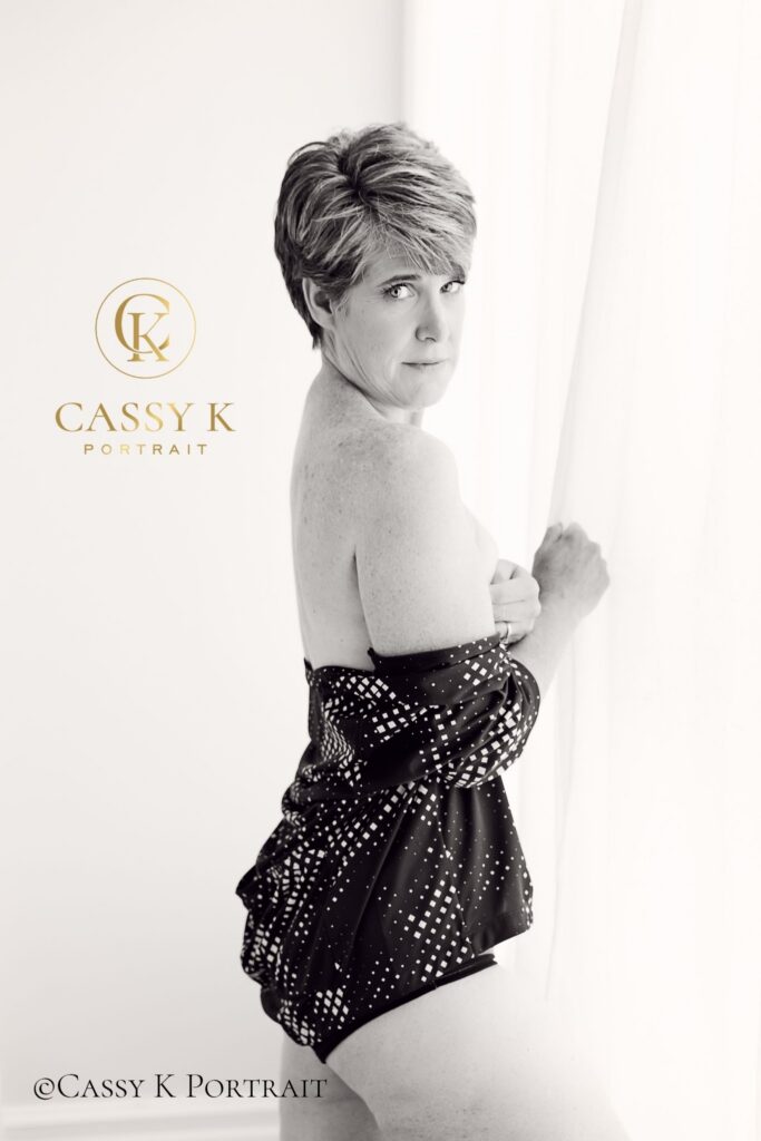 A beautiful woman with short hair wearing a bicycling shirt and shorts, showing how to confidently embrace sexy at any age during her luxury portrait session.