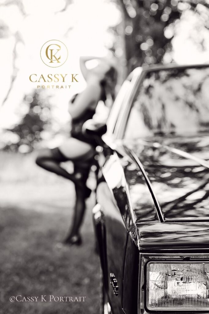 Blonde haired brown eyed woman posing on car gaining body confidence after kids