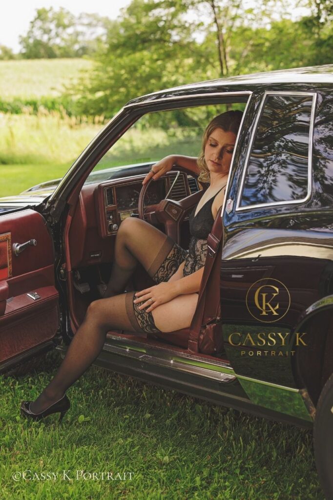 Blonde haired brown eyed woman sitting in car with door open gaining body confidence after kids