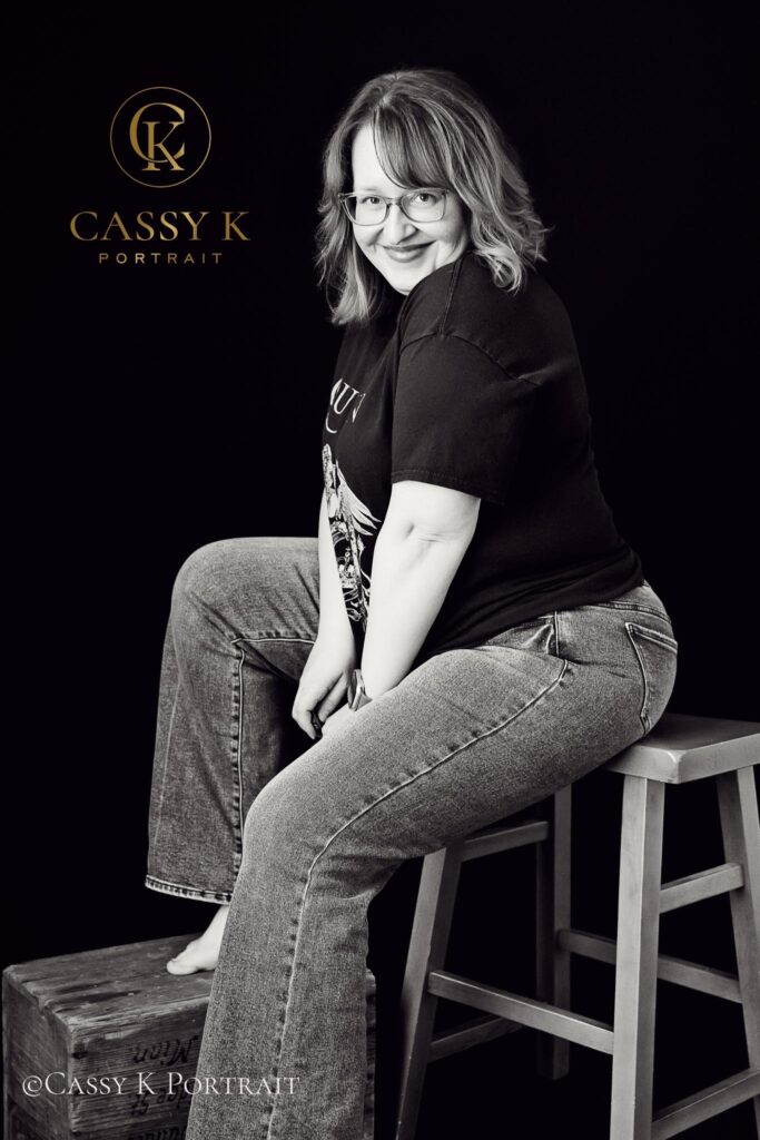 Sly Grin Blond hair and blue green eyed woman learns to love body image after 40 for headshot photo shoot