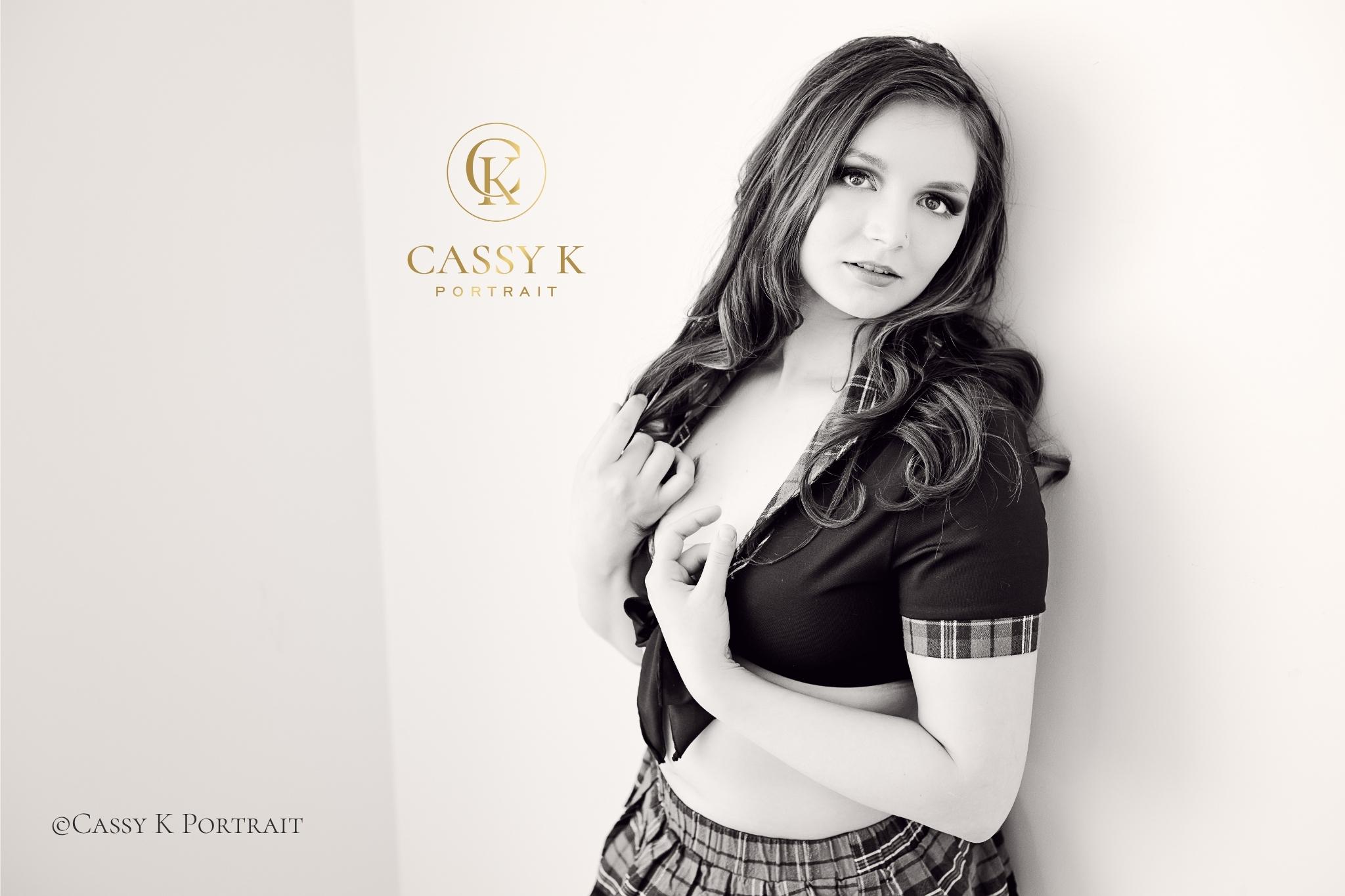 Red haired hazel eyed woman wearing crop top and skirt does Black and white boudoir photo shoot for self-love